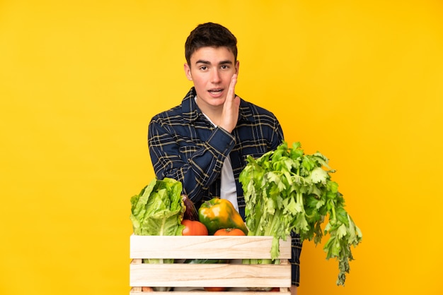 Hombre agricultor adolescente con verduras recién cortadas en una caja