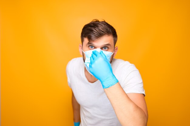 Un hombre ajusta una mascarilla médica desechable en su rostro.