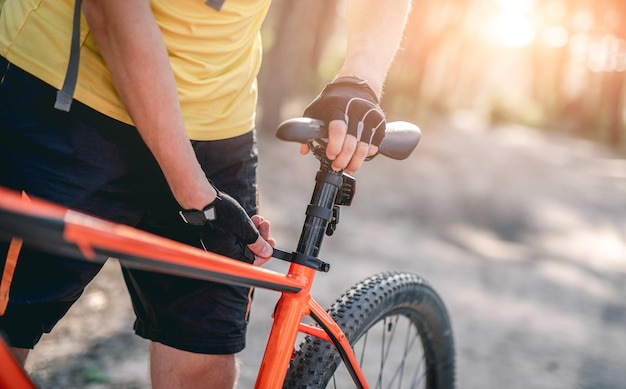 Hombre ajustando la altura del asiento de la bicicleta