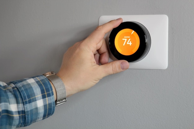 Foto el hombre está ajustando una temperatura en la sala de estar moderna