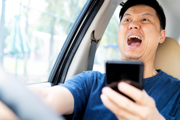 Un hombre al volante con un teléfono inteligente en la mano viola las normas de tráfico El concepto de accidente