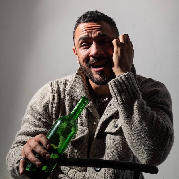 Hombre alcohólico con botellas de vino llorando. Hombre llorando deprimido. Hombre adicto al alcohol borracho bebiendo whisky, deprimido como alcohólico que sufre problemas de alcoholismo y adicción al alcohol.