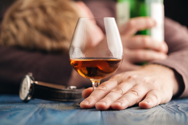 Hombre alcohólico dormir después de beber más whisky