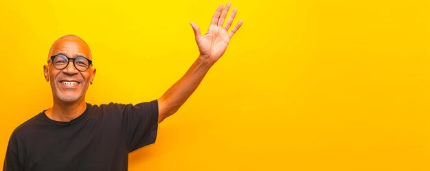 Foto un hombre alegre agita su mano contra un fondo amarillo con un amplio espacio para el texto creando una escena vibrante y alegre