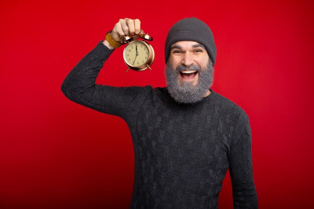 Hombre alegre con barba blanca con despertador, listo para año nuevo