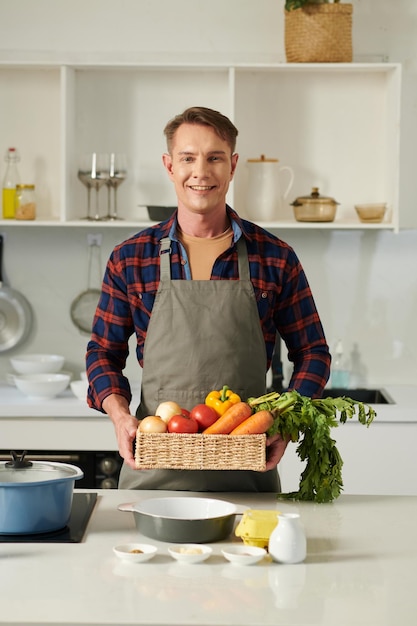 Hombre alegre con cesta de verduras