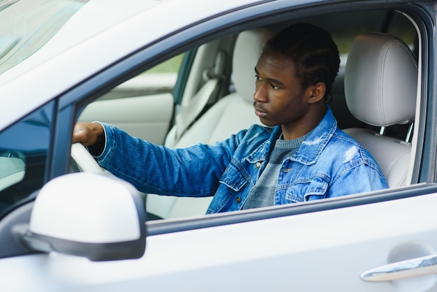 Hombre alegre dentro de su coche nuevo