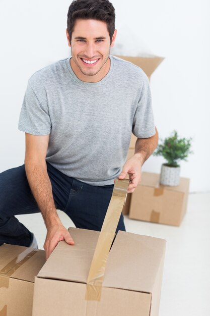 Hombre alegre envolviendo una caja