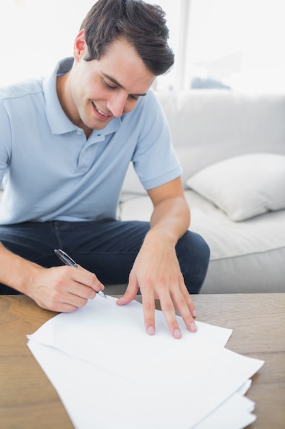 Hombre alegre escribiendo en un papel