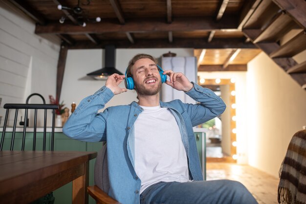 Un hombre alegre escuchando su música favorita.