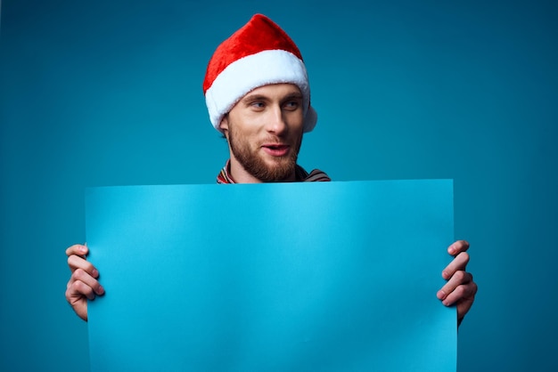 Hombre alegre en un fondo aislado del cartel de la maqueta azul de la Navidad