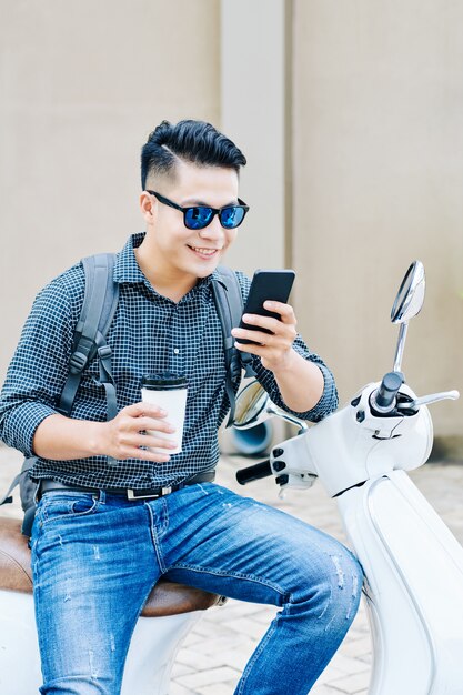 Hombre alegre leyendo mensajes de texto