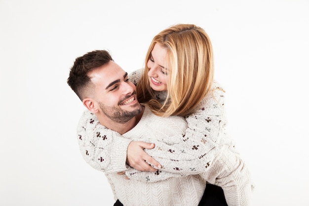 Foto hombre alegre que lleva a la mujer en la parte posterior