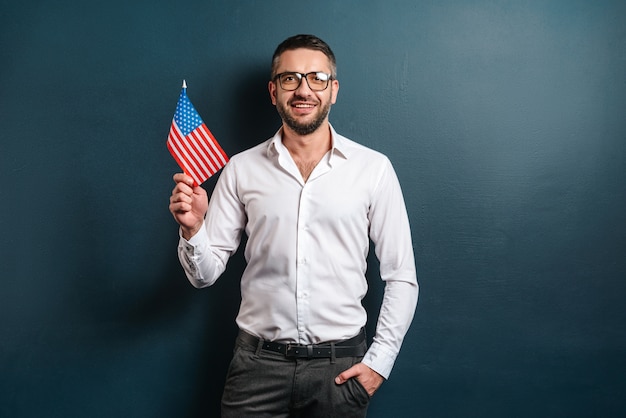 Hombre alegre que muestra la bandera de Estados Unidos.