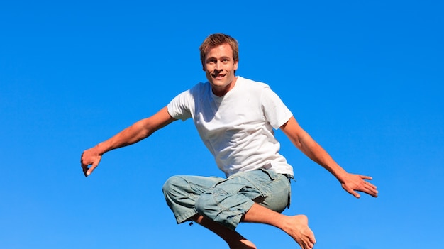 Hombre alegre saltando en el aire al aire libre