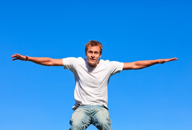 Hombre alegre saltando sobre un fondo azul