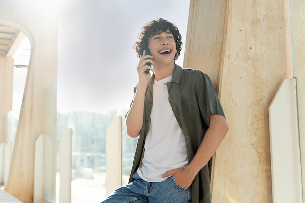 Foto hombre alegre sintiéndose feliz por teléfono y sonriendo