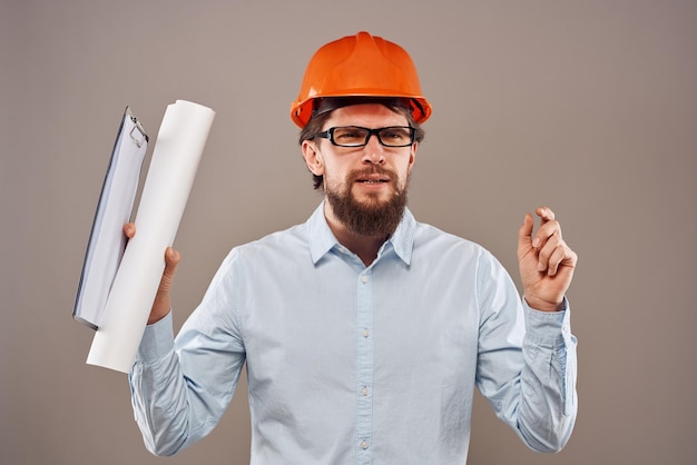 Hombre alegre sombrero duro naranja documentos construcción de planos profesionales