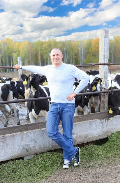 Hombre alimentando vacas en una granja al aire libre