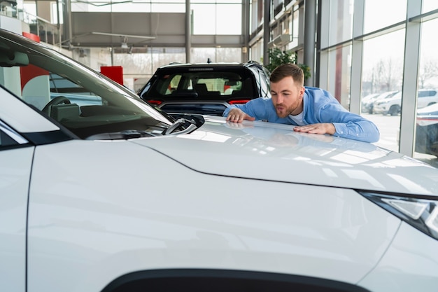 El hombre ama su auto nuevo