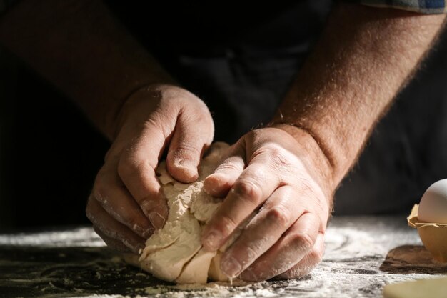 Hombre amasando masa en primer plano de la cocina