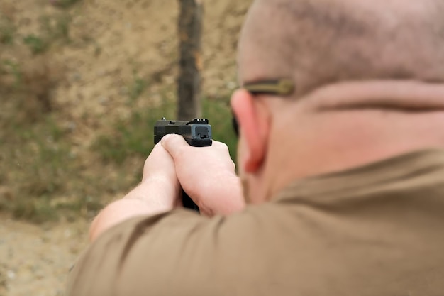 Un hombre amenaza con una pistola de combate que sostiene un arma en sus manos