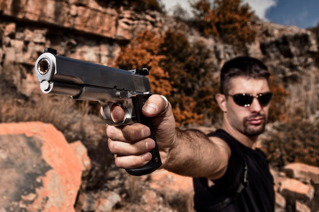 Foto hombre amenazante apuntando una pistola