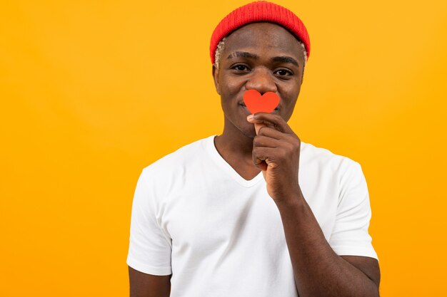 Hombre americano negro en camiseta blanca tiene tarjeta de San Valentín en amarillo