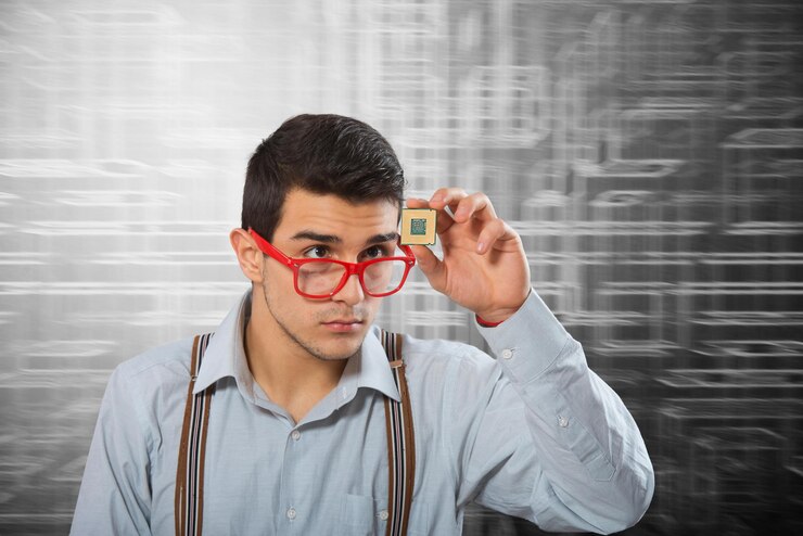 Foto hombre con anteojos enmarcados mirando el microprocesador en su mano