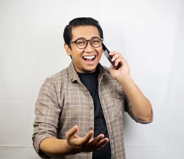 un hombre con anteojos hablando por celular.