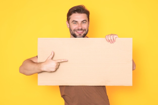 Hombre con un anuncio en blanco aislado en el fondo del estudio hombre sosteniendo un cartel en blanco vacío mostrando en blanco