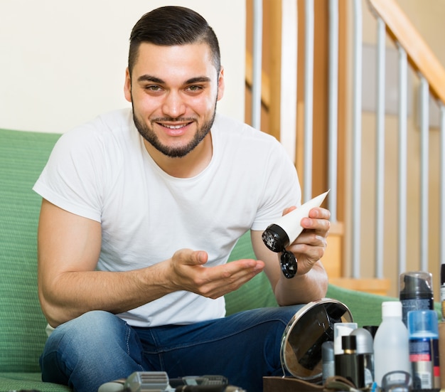 hombre aplicando crema facial en casa