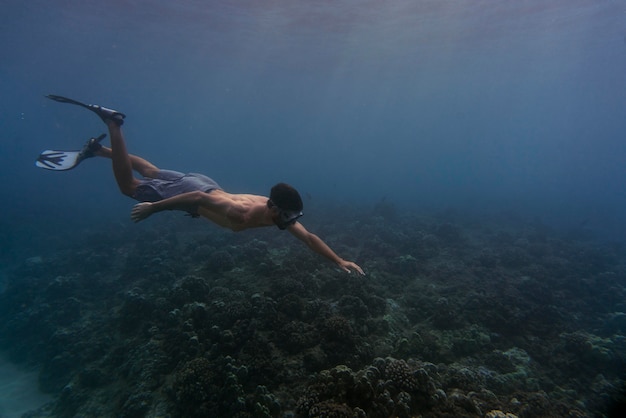 Foto hombre apnea con aletas bajo el agua