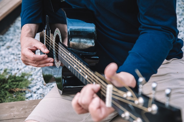 El hombre aprende a tocar la guitarra en las calles de la ciudad. Estilo de vida. Foto de alta calidad