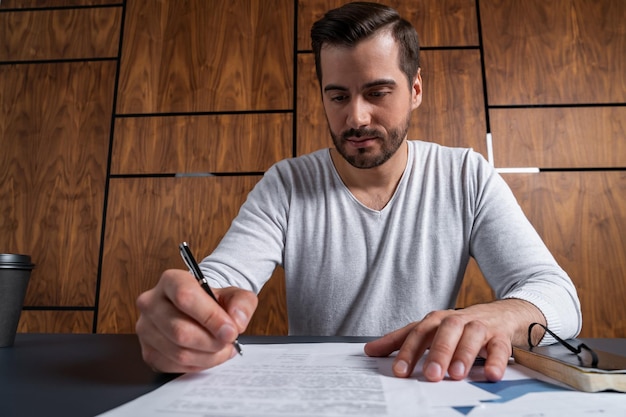 Un hombre apuesto que firma el contrato El concepto de entrar en poder legal para asumir responsabilidades Ropa casual