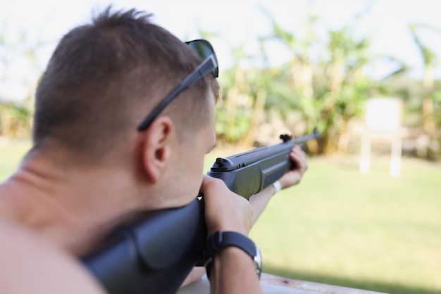 Foto un hombre apunta a un objetivo con un primer plano de pistola