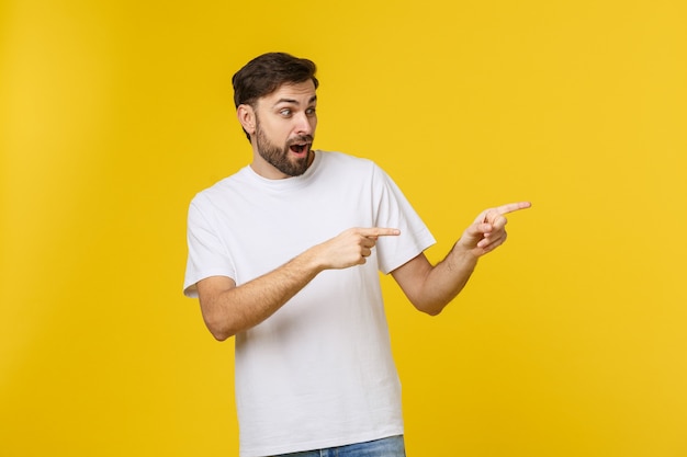 Hombre apuntando mostrando copia espacio aislado en espacio amarillo