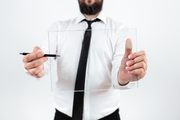 Foto hombre apuntando con la pluma al vidrio y mostrando nuevas ideas para lograr objetivos