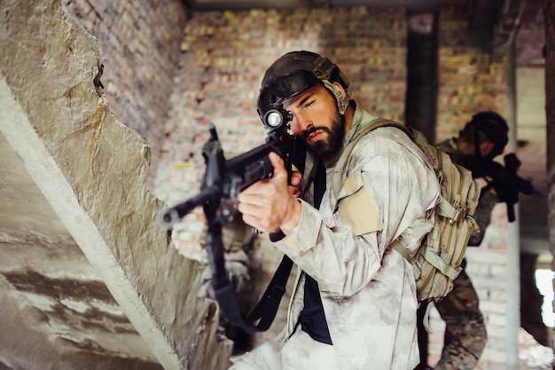 Hombre apuntando a través de la lente del rifle. Él está mirando hacia adelante.