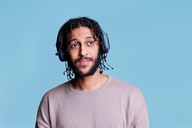 Hombre árabe disfrutando de la música con auriculares inalámbricos
