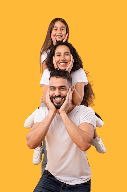 Foto hombre árabe feliz con esposa e hija en estudio de hombros