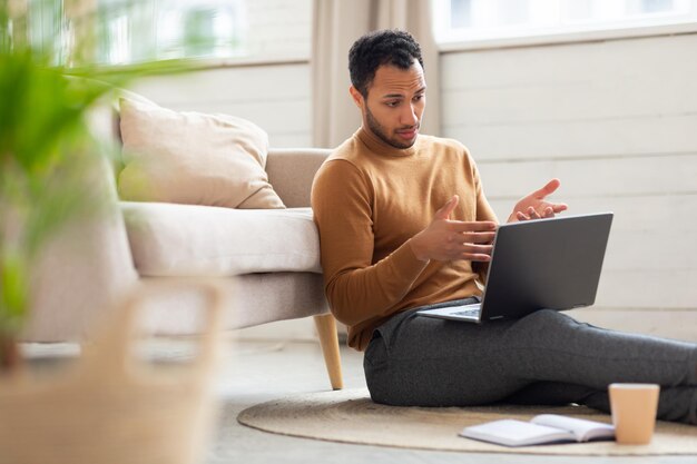 Hombre árabe que usa una computadora portátil para hacer una videollamada