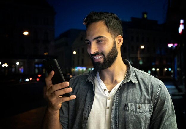 Hombre árabe sonriente barbudo joven que sostiene