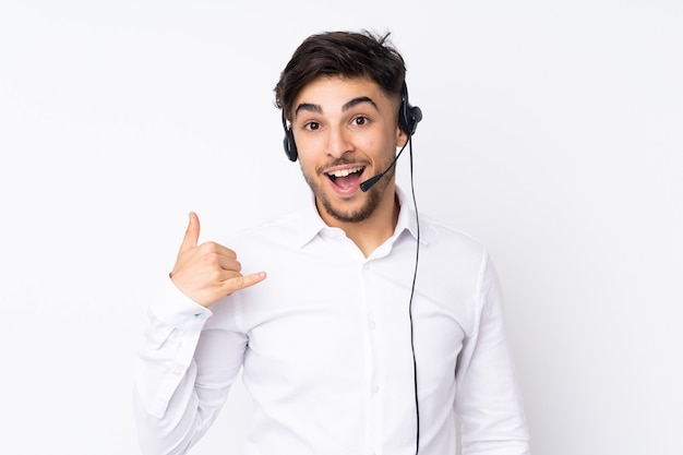 Hombre árabe telemarketer trabajando con un auricular aislado en blanco haciendo gesto de teléfono