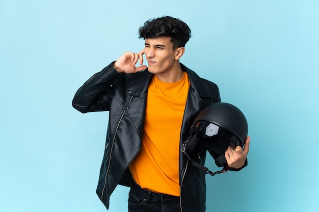 Hombre argentino con un casco de moto frustrado y cubriendo las orejas