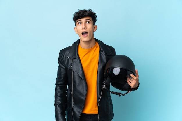 Hombre argentino con un casco de moto mirando hacia arriba y con expresión de sorpresa