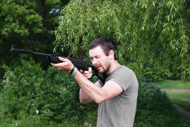 Foto hombre con arma contra las plantas