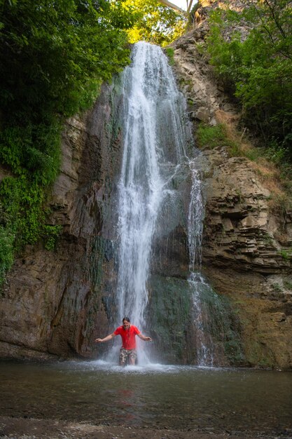 Foto el hombre de la armonía escarlata se encuentra con la cascada rítmica