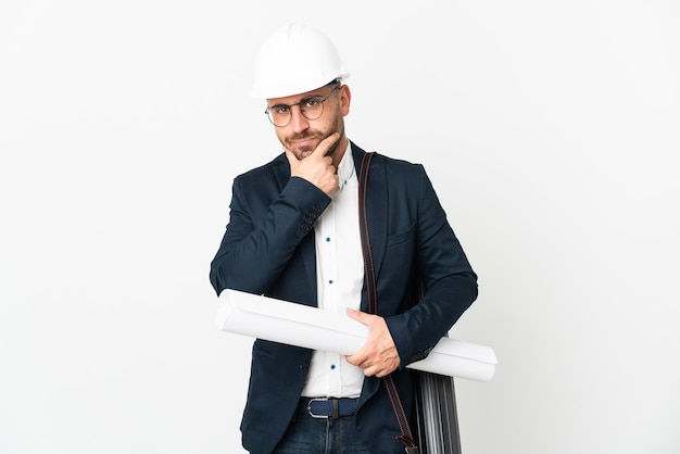 Hombre arquitecto con casco y sosteniendo planos aislados sobre fondo blanco pensando