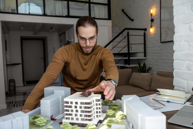 Foto hombre arquitecto con gafas trabajando en la oficina con en la creación de un nuevo complejo residencial diseñando el diseño de edificios